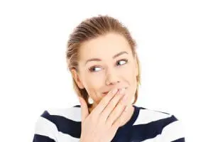 25394571 - a portrait of a pretty woman covering her lips in a oops gesture over white background