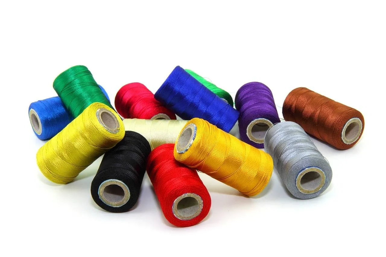 Entdecke leuchtend bunte Garnrollen auf Weiß - lass dich inspirieren und bringe Farbe in deinen Sommer!.