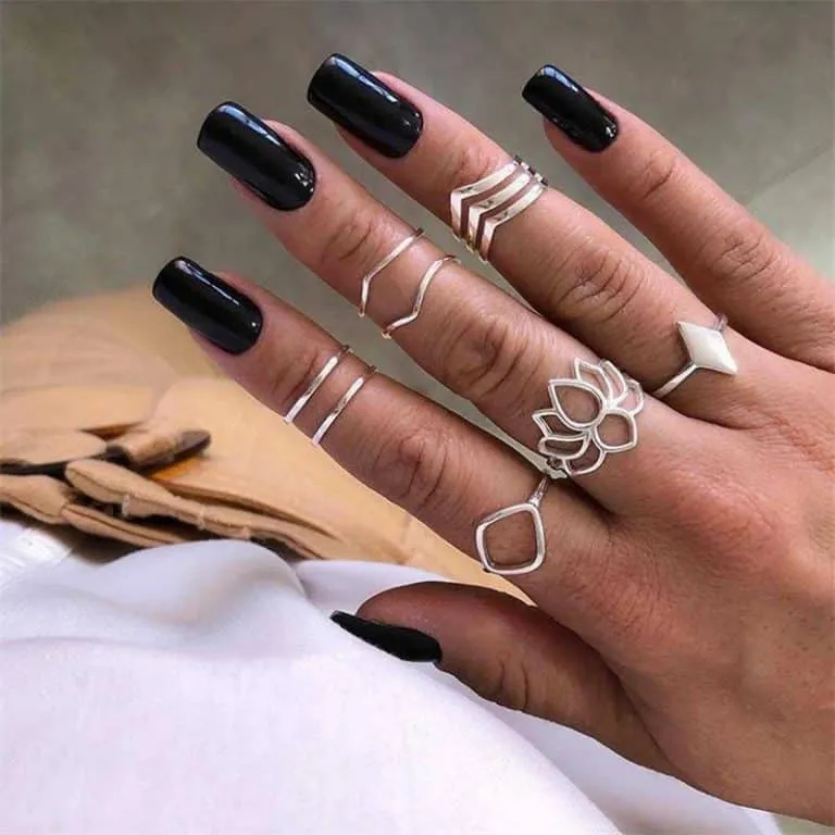 Die Hand einer Frau, geschmückt mit einem eleganten silbernen Ringset.