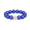 Das Magic Beads Ina Armband ist aus glänzenden blauen Perlen gefertigt und verfügt über eine einzelne runde, silberfarbene Perle, die mit kleinen, funkelnden Steinen verziert ist. Das Armband ist auf einem schlichten weißen Hintergrund abgebildet.