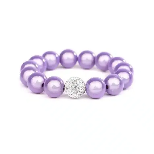 Das Magic Beads Ina Armband ist ein lila Perlenarmband mit einer einzelnen größeren Perle, die mit kleinen weißen Kristallen besetzt ist. Dieses exquisite Stück, das den Charme von Magic Beads hervorhebt, wird vor einem schlichten weißen Hintergrund präsentiert.