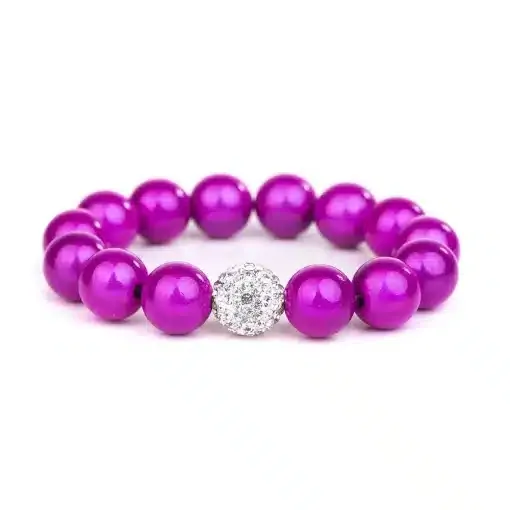 Das Magic Beads Ina Armband ist ein dehnbares Armband mit 16 leuchtend violetten Perlen, die perfekt um eine zentrale runde Perle angeordnet sind, die mit klaren, funkelnden Strasssteinen besetzt ist. Das Design ist einfach und symmetrisch, was es zu einem eleganten Accessoire macht.