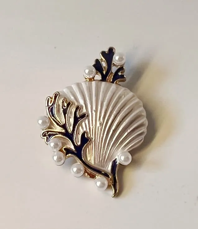 Entdecken Sie die Meeresschönheit in Form einer trendigen Brosche! Stell dir eine elegante Muschel mit goldglänzenden Rändern vor, geschmückt mit einem tiefblauen Algenmuster und kleinen perlenartigen Verzierungen. Sie fängt die Eleganz des Ozeans perfekt ein und verleiht Ihrem Outfit das gewisse Etwas. Lass dich von dieser stilvollen Kreation verzaubern und bring maritimen Glamour in deinen Look!.