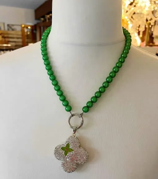 Entdecke das Zauberhafte: die magische Perlen-Halskette! 🌿✨ Schmiege dich im eleganten Style mit runden, grünen Perlen an und lass dich vom kleeblattförmigen Anhänger verzaubern, der mit funkelnden klaren Edelsteinen besetzt ist. Der zentrale grüne Stein setzt dem Ganzen die Krone auf. Trag das Glück am Hals und zieh alle Blicke auf dich! 💚🌟.