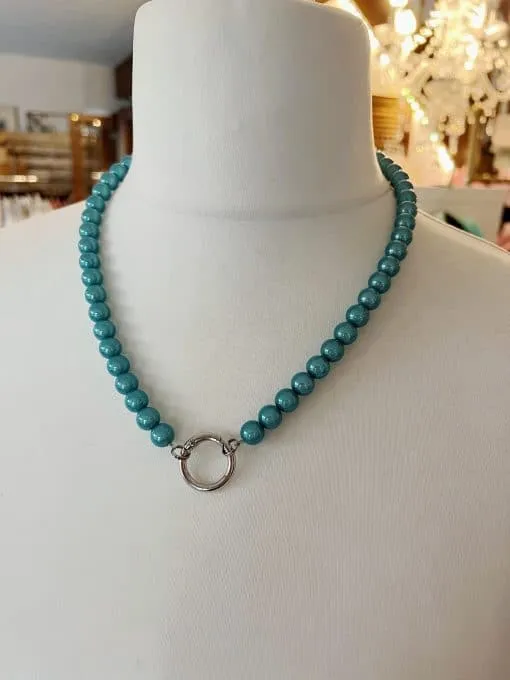 Entdecke die Magie der Perlen! Stell dir vor, wie diese einfache türkisfarbene Halskette dein Outfit verzaubert. An einer weißen Büste präsentiert sich der elegante Anhänger in Silber – ein absoluter Hingucker. Im sanften Licht schimmernder Kronleuchter entfaltet er seine ganze Pracht und zieht alle Blicke auf dich. Hol dir dieses zauberhafte Accessoire und lass dich von seiner geheimnisvollen Ausstrahlung begeistern!.