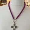 Entdecke die Magie! 🌟 Die Simple Halskette mit runden, violetten Perlen und einem silbernen Kreuzanhänger mit ovalem Schmuckstein wartet auf dich! Elegant inszeniert auf einer Büste, zieht dieses Schmuckstück alle Blicke auf sich. Die Umgebung aus stilvollen Regalen und sanften Lichtern verstärkt das magische Ambiente – genau das Richtige für Ihren individuellen Look. Gönn dir das gewisse Etwas und spüre die Faszination jeden Tag aufs Neue. ✨ Verleihe deinem Stil den ultimativen Touch von Glamour!.