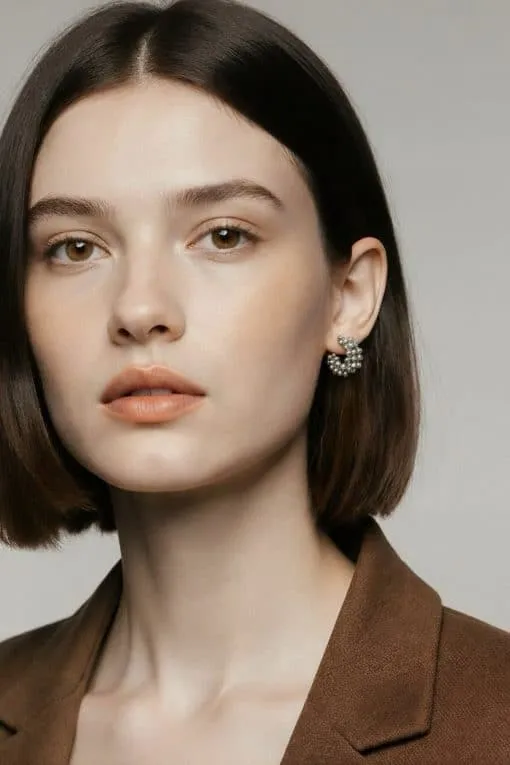 Setz ein Statement mit deinem Look: Kurzes braunes Haar, brauner Blazer und auffällige Aurora Hoops aus Silber - mutig und modern.