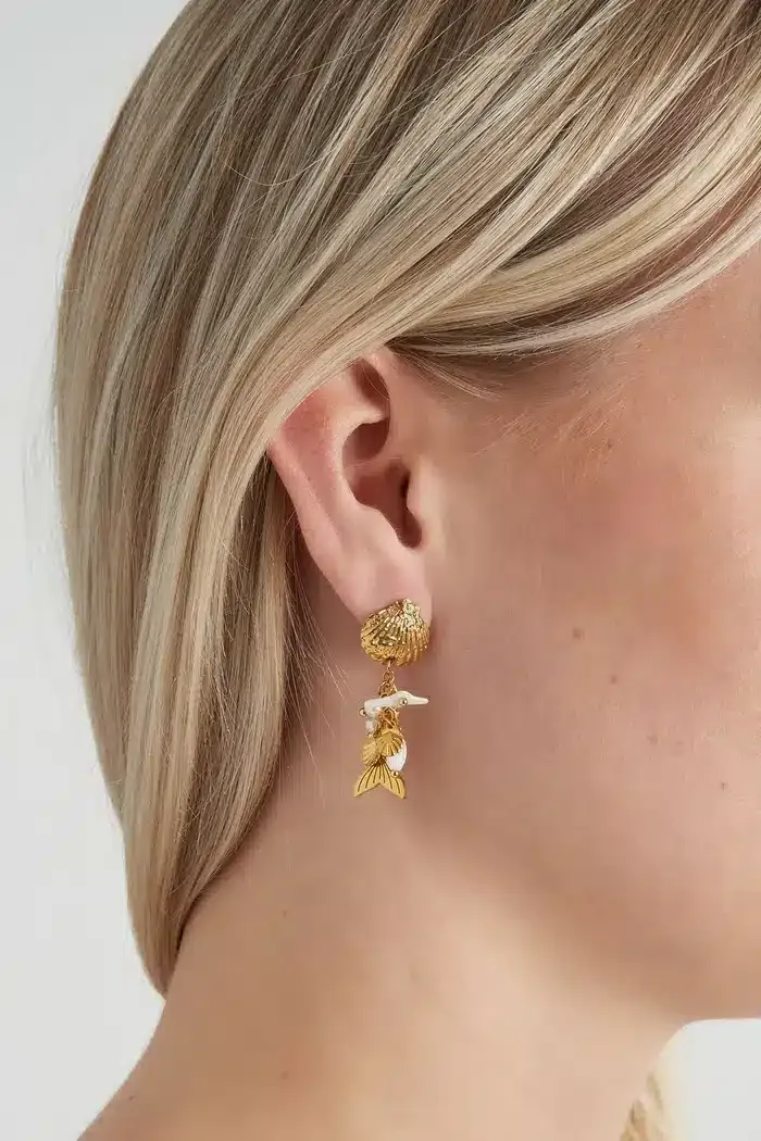 Entdecken Sie die Magie der Meerjungfrauenwelt mit diesem einzigartigen, goldenen Ohrring in Form einer zauberhaften Meerjungfrau! Lass deine blonden Haare diesen funkelnden Hingucker umspielen und setze ein modisches Statement, das alle Blicke auf dich zieht. Perfekt für deinen modernen Look – sei bereit, die Unterwasserwelt stilvoll zu erobern und zeige deine Individualität mit diesem faszinierenden Accessoire. Tauche ein in eine Welt voller Glamour und Abenteuer!.