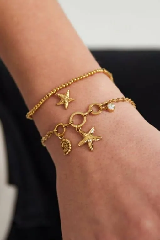 Hey du! Stell dir vor, du trägst zwei atemberaubende „I Sea You“ Armbänder aus Gold an deinem Handgelenk. Das obere Armband glänzt mit einem schlichten Stern-Charm, das untere verzaubert mit einer Vielzahl von Anhängern, darunter ein weiterer Stern und ein runder Anhänger. Beide Armbänder bestechen durch ihr filigranes Kettendesign und sind die perfekte Ergänzung für deinen individuellen Look. Gönn dir diesen Hauch von Eleganz und Stil – weil du es verdienst! ✨.