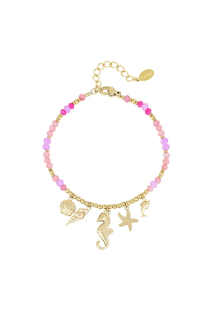 Entdecke das „Malibu (Kopie)“ Armband: Dein Must-Have für den Sommer, das garantiert alle Blicke auf sich zieht! Verspielte pinke und lila Perlen setzen Akzente, während fünf goldene Anhänger – Muschel, Seepferdchen, Delfin, Seestern und Schale – Deinem Look einen Hauch von Meereszauber verleihen. Der goldene Kettchenverschluss mit Lobsterverschluss passt perfekt an dein Handgelenk. Style Dich modern und erfrischend lässig – Sommerfeeling pur zum Mitnehmen!.