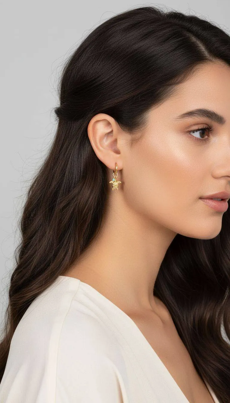 Goldene Schildkröte Ohrstecker am Ohr der Frau. Süße Meerestier-Ohrringe für Damen.