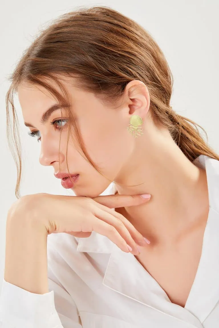 Stell dir vor, du bist die Frau mit dem im Nacken geschnürten braunen Haar und dem auffälligen goldenen Ohrring. Du ruhst deinen Kopf entspannt auf deiner Hand, während du seitlich in die Welt hinausblickst. In deinem eleganten weißen Shirt und vor einem sanft verschwommenen Hintergrund wirkst du wie das lebendige Symbol von Meer Liebe’s ästhetischem Zauber. Hier verschmelzen Stil und Ruhe zu einem perfekten Moment – genau wie bei dir!.