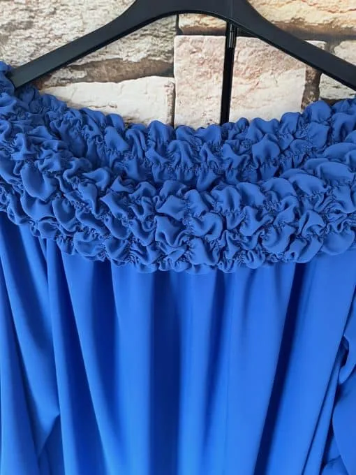 Entdecke den Stilmagneten Sophia Chic – das ultimative blaue Off-Shoulder-Kleid, das deinen Look auf ein neues Level hebt! Die verspielten Rüschen am Ausschnitt verleihen dir genau die richtige Portion Eleganz und Frische. Stell dir vor, wie dieses modische Highlight an einem schwarzen Bügel hängt und perfekt vor einem trendigen Backsteinmuster zur Geltung kommt. Schnapp es dir und sei bereit, im Rampenlicht zu stehen!.