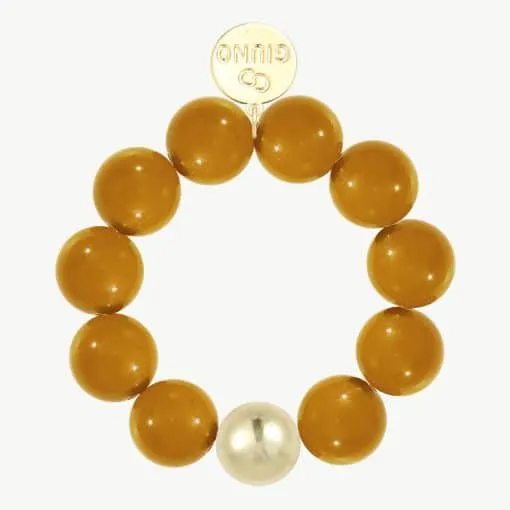Du suchst nach einem Schmuckstück, das aus der Masse heraussticht? Das GIUNO Bold Beads Armband ist genau dein Statement-Piece! Acht warme Bernsteinperlen und eine strahlend-weiße Perle reihen sich dynamisch um dein Handgelenk. Das Highlight: Eine edle, vergoldete Scheibe mit feiner Gravur, die deinen Look einzigartig macht. Ob Casual oder Business - mit diesem Armband setzt du auf moderne Eleganz und zeigst Stilbewusstsein zu jedem Anlass.
