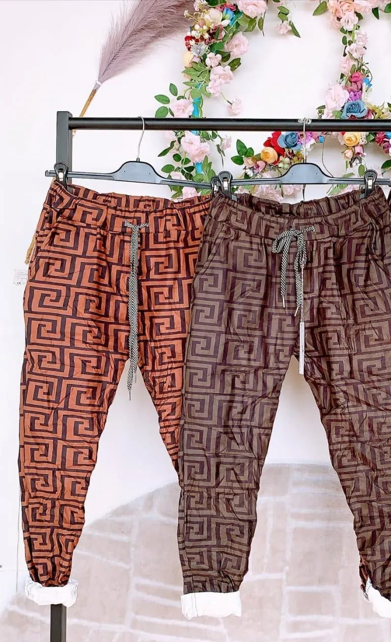 Entdecke deinen Style: Deine Geo Chic Jogpants mit angesagten Mustern warten, stylisch inszeniert unter floralen Akzenten.