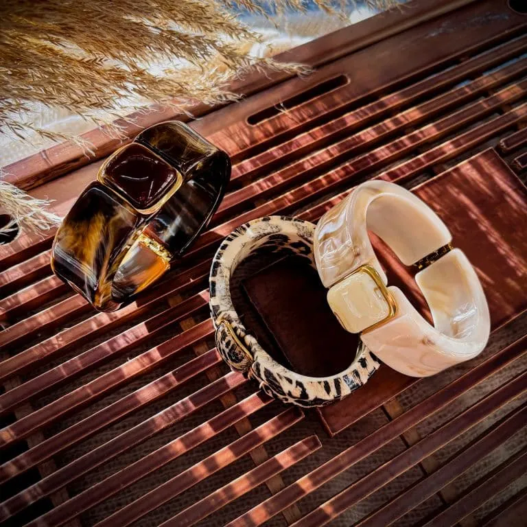 Setze ein Statement mit diesen zwei klobigen Armbändern in Braun und Creme auf edlem Holz - dein ultimativer Trend-Look!.