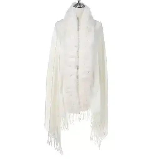 Entdecke den Jolina Poncho Schal: Weißes Design mit flauschigem Fellbesatz und Fransen - dein Must-have für luxuriöse Looks!.