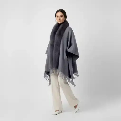 Trage den grauen Jolina Poncho Schal mit Fell und Fransen zu weißen Hosen und Heels - dein moderner Look für selbstbewusste Auftritte!.