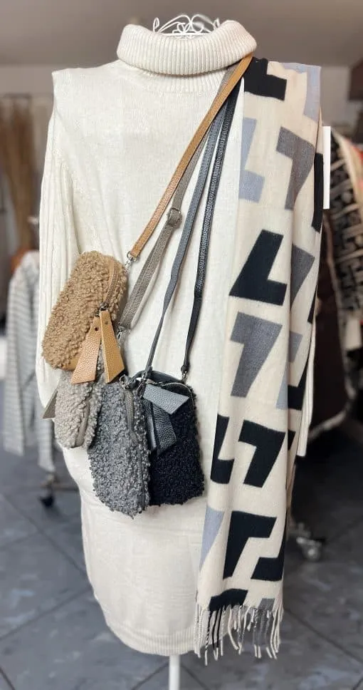 Erlebe modernsten Chic: Du trägst ein cremefarbenes Rollkragenkleid, vier edle Crossbody-Bags und die Handy Teddy Tasche.
