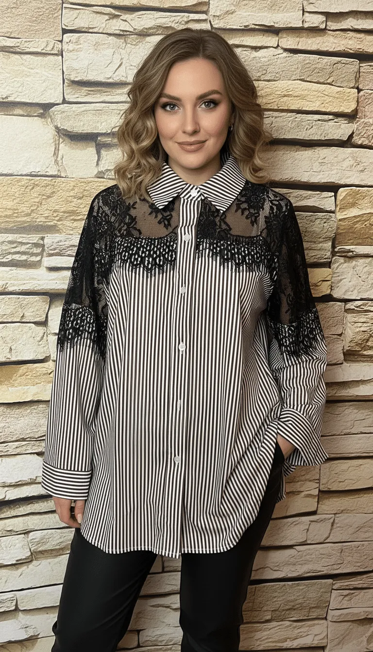 Du strahlst Selbstbewusstsein aus, trägst ein modernes Streifenshirt mit Spitzenakzenten vor urbaner Steinwand und lächelst charmant.