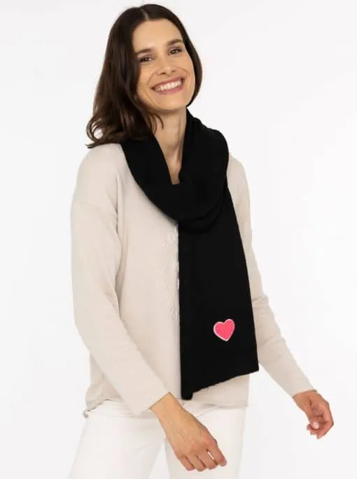 Du strahlst in deinem beigen Pullover und stylischen schwarzen Schal mit süßem pinkem Herz - so modern wie du selbst!.