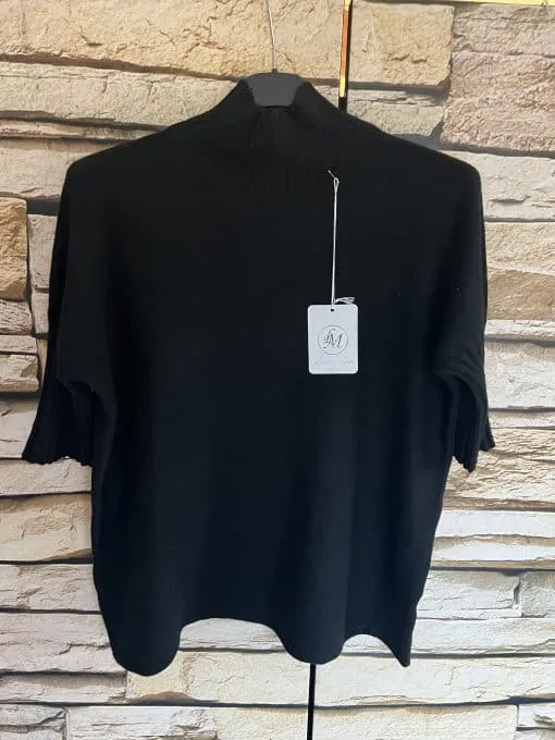 Erlebe zeitlose Eleganz: Hol dir den Élégance Classique Pullover - dein Statement in Schwarz vor trendigem Ziegelmuster-Hintergrund.