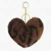 Verleihe deinem Look das gewisse Etwas: Der Plüsch-Liebes-Schlüsselanhänger in Braun und Schwarz mit goldenem Ring verzaubert dich!.