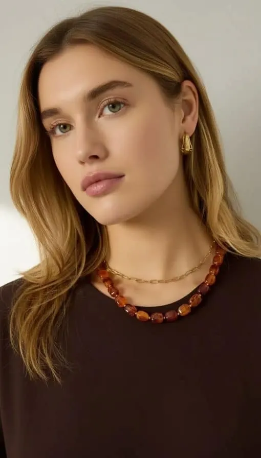 Mit deinem hellbraunen Haar, dem dunklen Top, goldenen Ohrringen und den stylischen Retro-Bead Ketten ziehst du alle Blicke auf dich.