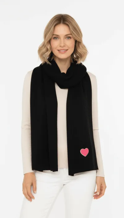 Spüre den Winterzauber: Trage den Zwillingsherz Winterliebe-Strickschal mit pinkem Herz, kombiniert zu Beige und Weiß.