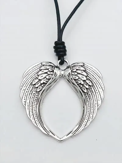 Trage die Himmlische Flügel Lederbandkette: Silberne Herzflügel, detailreich graviert, an schwarzem Band - dein stylisches Statement!.