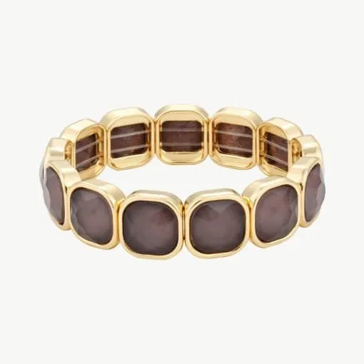 Erlebe Luxus am Handgelenk: Du trägst ein modernes Goldarmband mit quadratischen, funkelnden Braunsteinen im edlen Design.