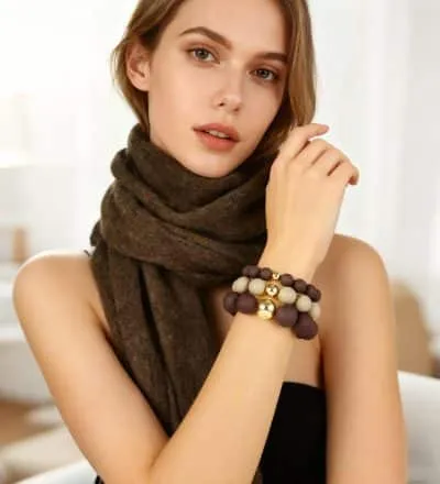 Home Trage das Giuno Bold Beads Armband - stylisch kombiniert mit braunem Schal vor sanftem Hintergrund. Dein Look, dein Statement.