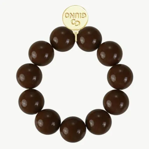 Setze ein Fashion-Statement mit dem GIUNO Bold Beads Armband: Große braune Perlen, goldener Anhänger - dein Trend-Highlight!.