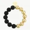 Erlebe deinen Style: Ein modernes Armband mit mattschwarzen und glänzend goldenen Perlen sowie rundem Goldanhänger.