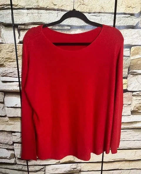 Erlebe pure Gemütlichkeit: Der Soft Line Pullover in Rot wartet auf dich - kuschelige Ärmel, topmodern vor Steinwand inszeniert.