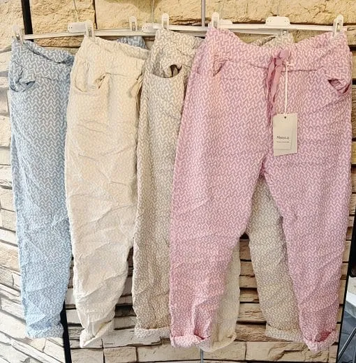 Entdecke deinen Style: Unsere zauberhaften Relax Hosen in Blau, Weiß, Grau und Pink warten auf dich vor urbaner Backsteinwand!.