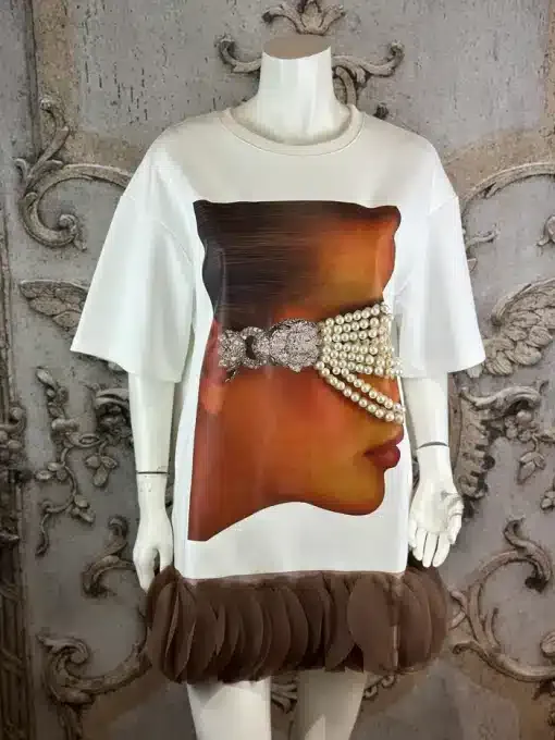 Entdecke dein Mode-Statement: Weißes Kleid mit Face-Print, edlen Perlen-Akzenten und modernem Rüschenbesatz am Saum.
