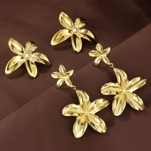 Entdecke jetzt die Aurelia Blossom Ohrstecker & Hänger in Gold - dein modernes Schmuck-Highlight strahlt elegant auf Braun.