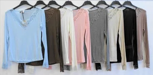 Entdecke deinen Style: Acht BASIS KASCHMIR Longsleeves mit Spitzenbesatz in trendigen Farben warten auf dich an schwarzen Bügeln.