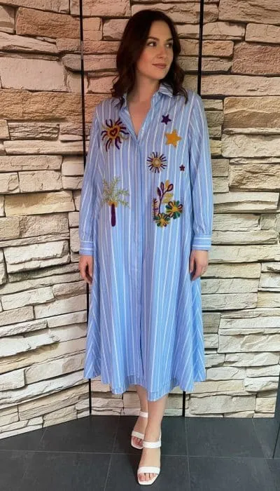 Home Erlebe den sommerlichen Look: Trage das geblümte Streifenkleid, weiße Sandalen & dein LOVE Sweatshirt locker über die Schultern.