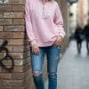 Mit dem pinken New York City Sweatshirt und coolen Ripped Jeans setzt du urban ein Statement - lässig am Backstein lehnend.