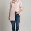 Erlebe deinen modernen Look: Du trägst die Soft Basics Bluse in zartem Rosa, kombiniert mit Blue Jeans und weißen Sneakern.
