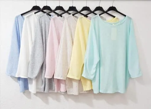 Stell dir vor, du wählst aus sieben trendigen Pastellhemden - stilvoll auf schwarzen Bügeln vor einer weißen Wand.