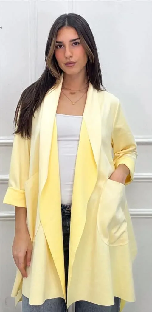 Zeige deinen Style: Du trägst eine gelbe Strickjacke, weißes Top und Jeans - lässig-modern vor strahlend weißer Wand.