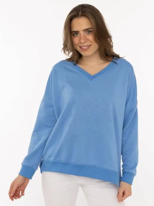 Entdecke deinen neuen Look: Du strahlst in deinem hellblauen V-Neck Sweatshirt mit stylischem 3D-Print vor cleanem Hintergrund.
