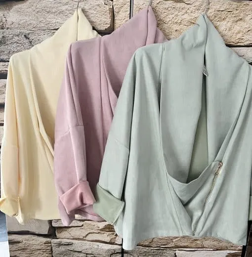 Entdecke deinen neuen Look: Die Casual Luxe Jacke in Pastelltönen bringt modernen Chic vor der coolen Steinwand zur Geltung.