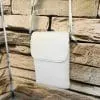 Entdecke deinen neuen Lieblingsbegleiter: Diese weiße Leder-Crossbody-Bag setzt dich stilvoll vor angesagter Steinwand in Szene.
