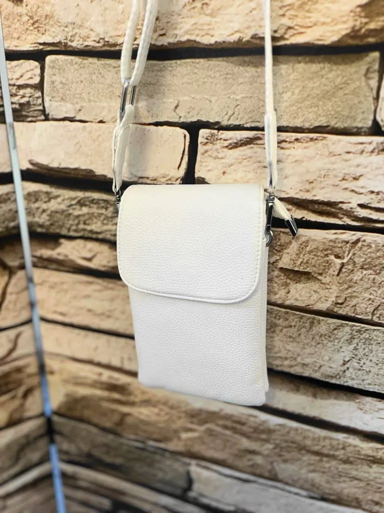 Entdecke deinen neuen Lieblingsbegleiter: Diese weiße Leder-Crossbody-Bag setzt dich stilvoll vor angesagter Steinwand in Szene.