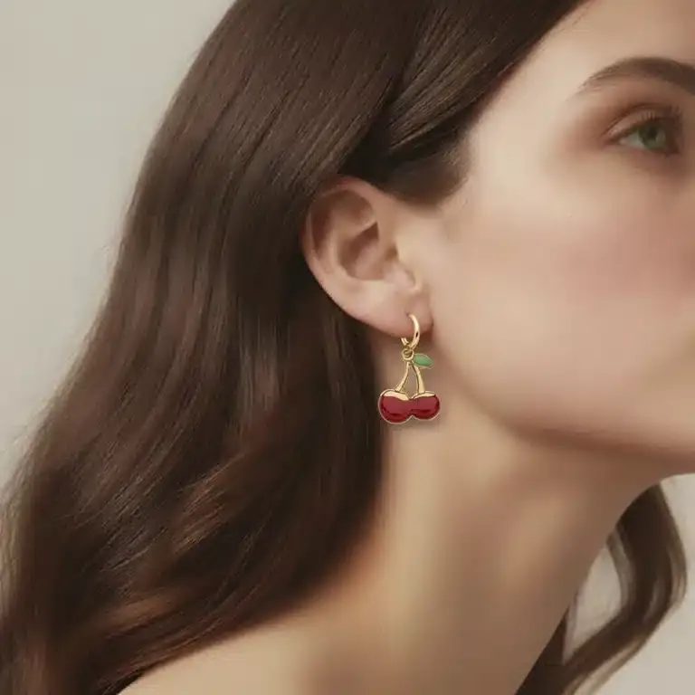 Setze ein Statement mit dem Cherry Darling Creole an dein Ohr - gold, kirschförmig, modern und stilvoll mit roten Akzenten.