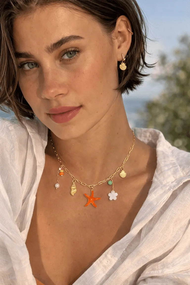 Die goldenen Muschelohrringe von Sand & Meer und die Seestern-Halskette mit Blumencharme verleihen jedem Outfit küstennahe Eleganz, einen lebendigen Stil und einen einzigartigen Reiz.